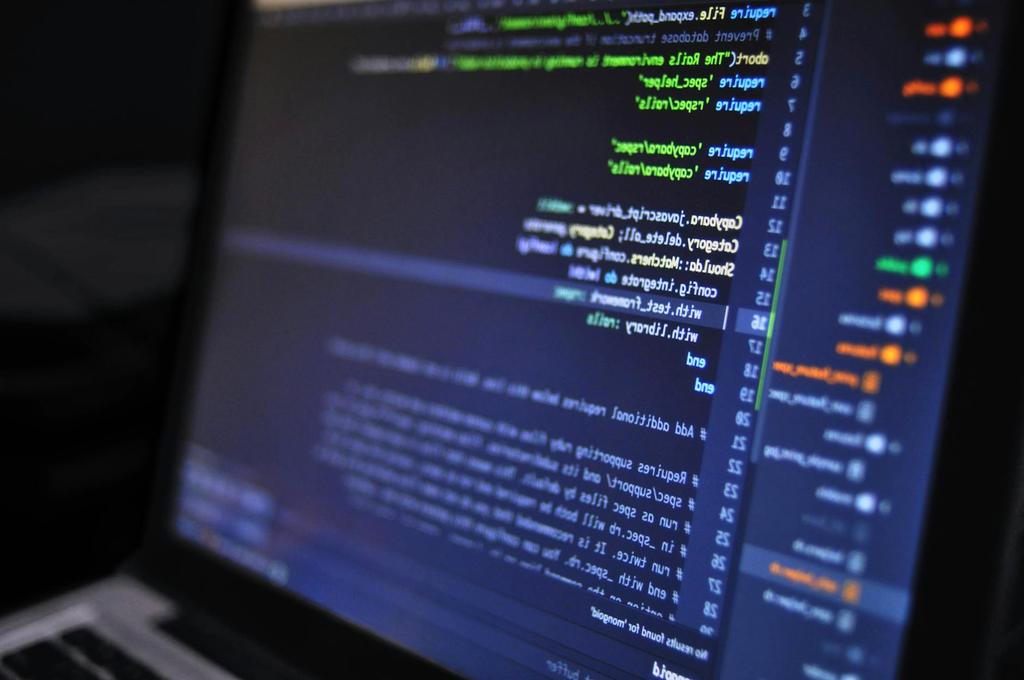 Modern software development workspace with multiple monitors showing code